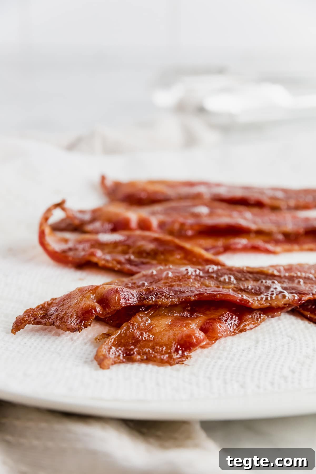 Crispy Oven-Baked Bacon: Foolproof Method for Perfect Slices 2 A plate covered with a paper towel and bacon straight from the oven.