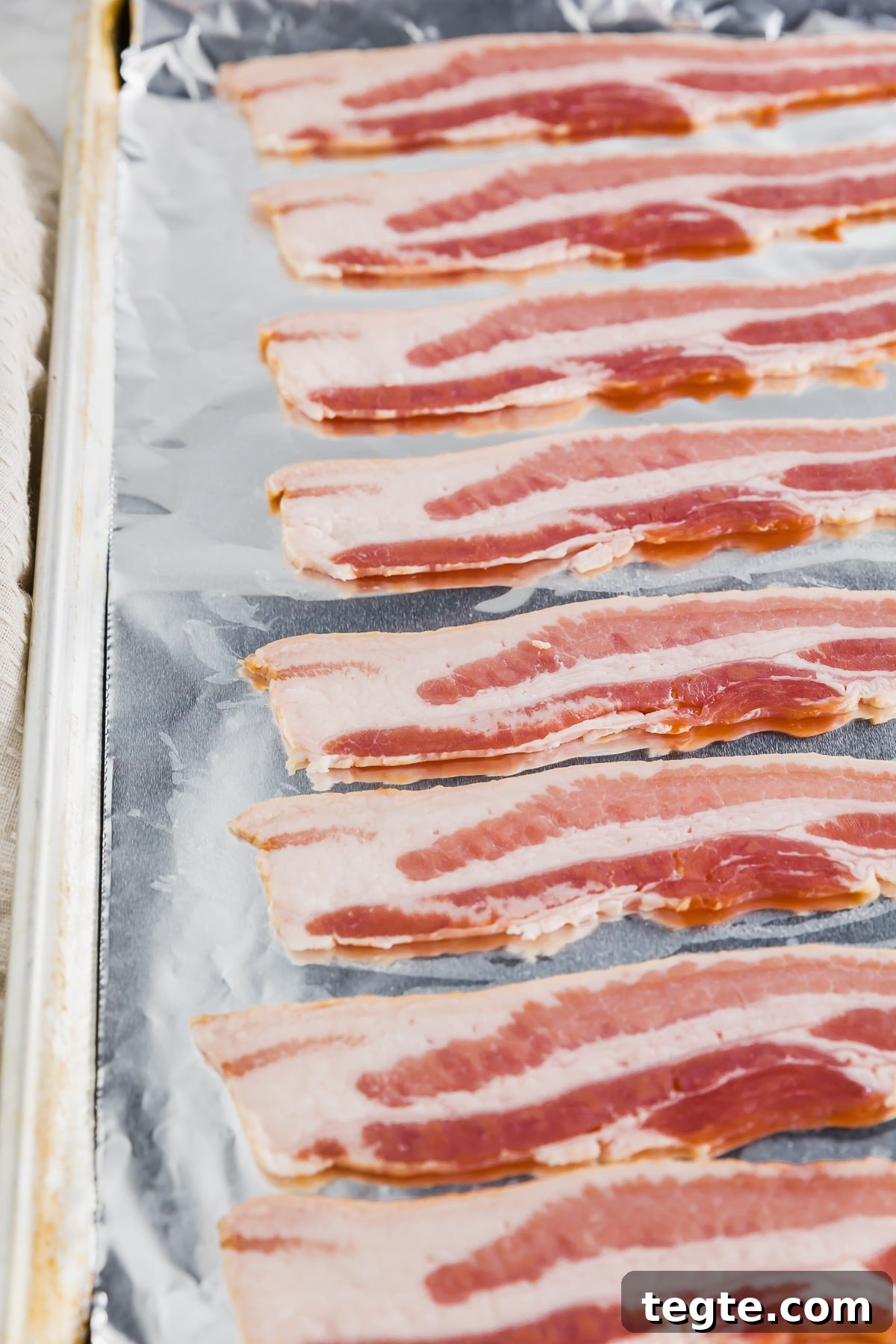 Crispy Oven-Baked Bacon: Foolproof Method for Perfect Slices 3 A baking sheet covered with aluminum foil and topped with bacon ready to be baked in the oven.