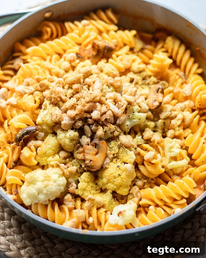 26 Cozy Vegan Dinners to Warm Your Winter Nights 4 overhead view of a pot holding creamy vegan red pepper pasta sauce with coconut milk, mushrooms, and roasted cauliflower.