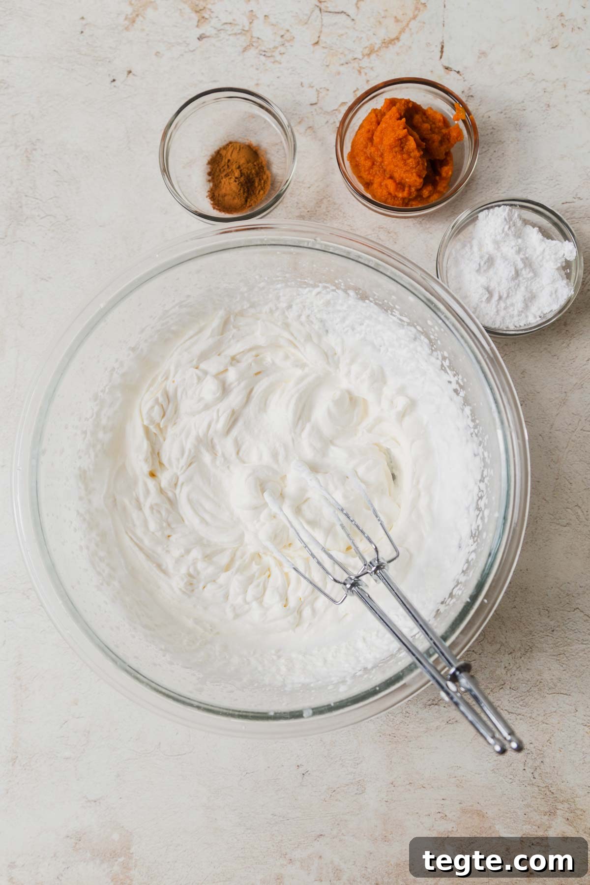 Pumpkin-Spiced Whipped Cream Recipe for Fall Desserts 4 whippped cream with other ingredients around it.