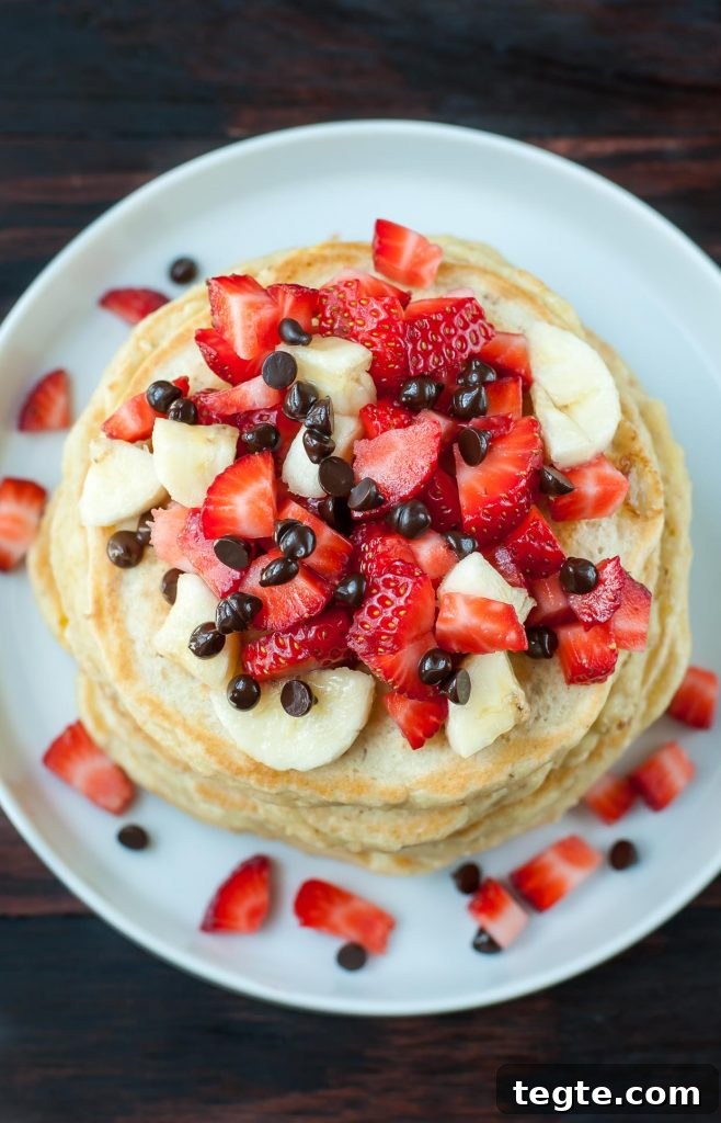 Banana Split Pancake Recipe: Fluffy Pancakes with Strawberry, Pineapple & Chocolate 4 Banana Split Pancake stack with toppings
