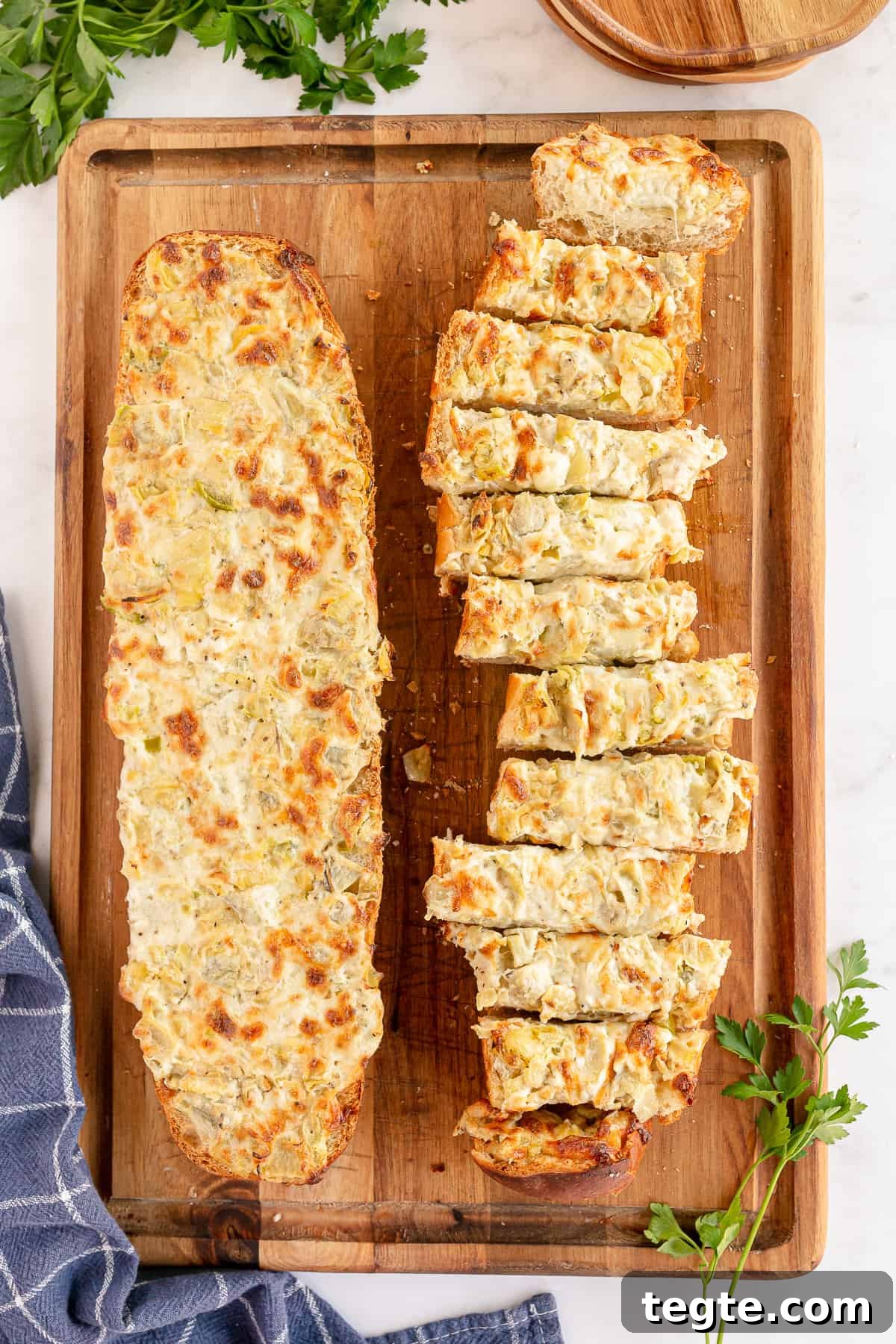 Cheesy Artichoke Pull-Apart Bread for Parties and Snacks 7 Sliced artichoke bread on a cutting board shot from over the top.