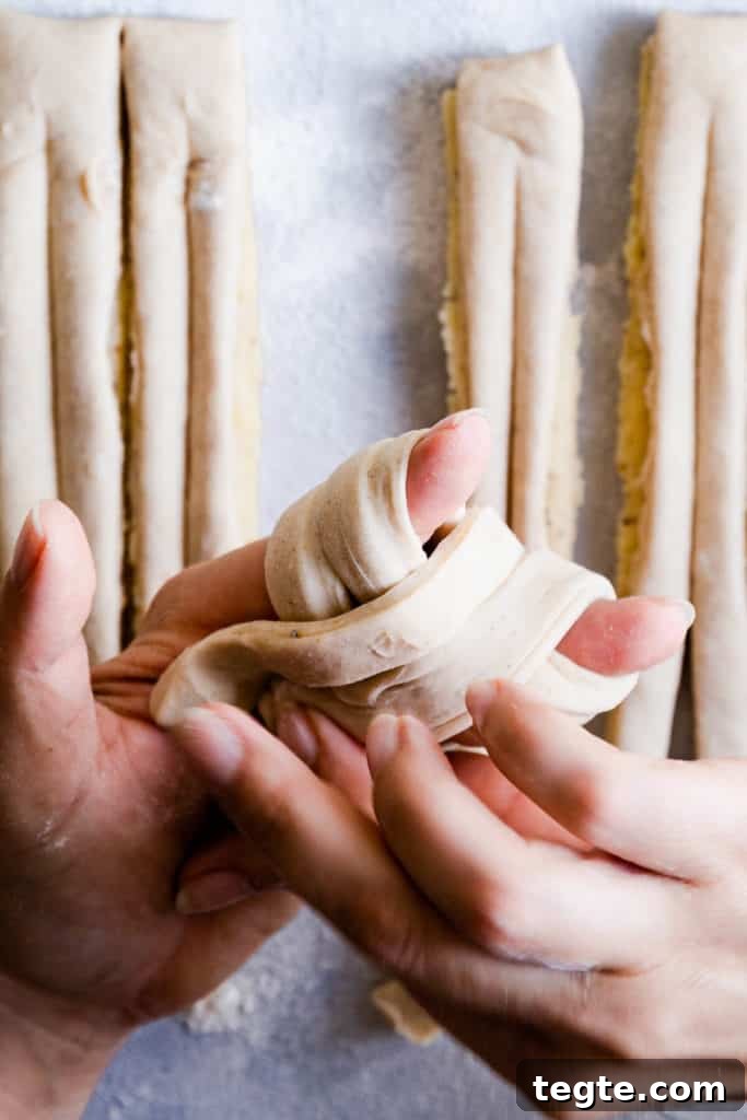 Authentic Swedish Cardamom Buns (Kardemummabullar) Recipe 15 close up of hands shaping the dough