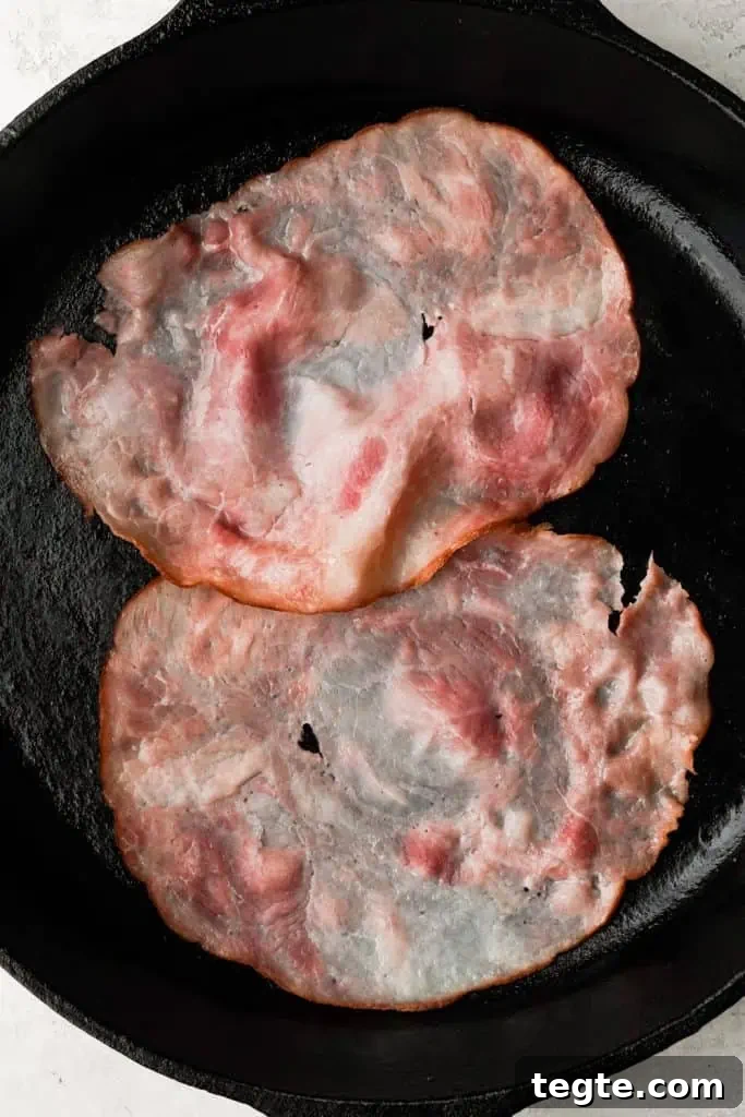 savory dutch baby toppings two slices of ham cooked in a cast iron skillet