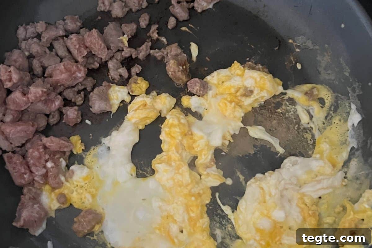 Hearty Country Breakfast Bowl Recipe for Morning Energy 5 Eggs and sausage cooking in a skillet.