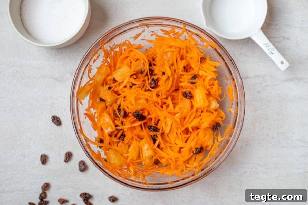 Carrot Salad Recipe Mixing bowl with carrot raisin salad tossed together.