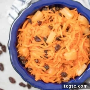 Zesty Carrot and Raisin Salad with Honey-Lemon Dressing 2 Carrot Raisin Salad with pineapple in a blue serving bowl.