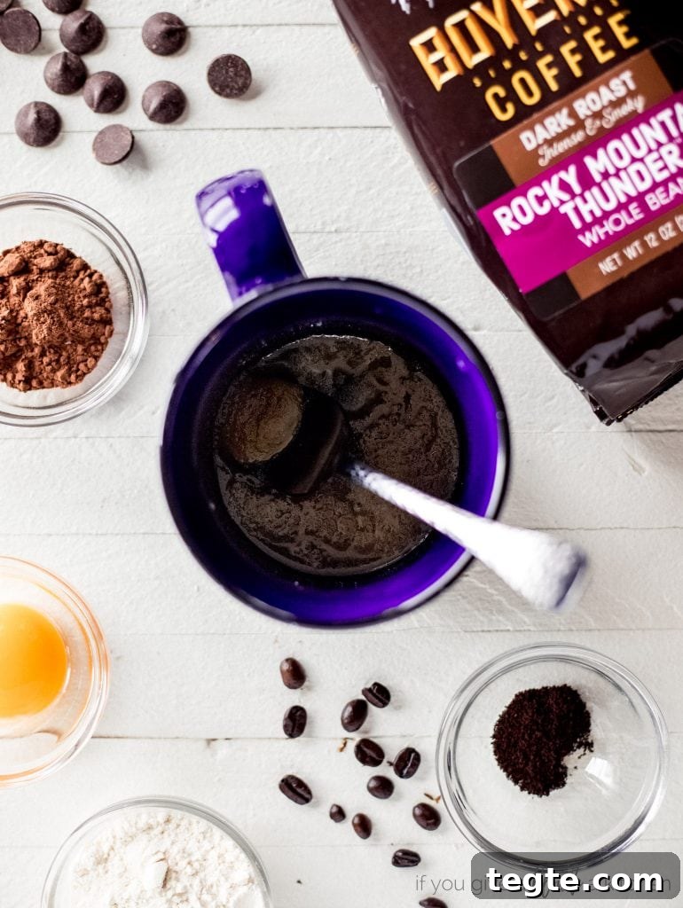 Microwave Double Chocolate Chip Mug Cookie Recipe 3 blue mug with spoon and double chocolate chip cookie ingredients