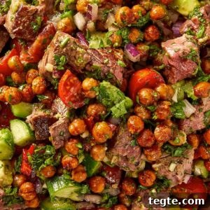 Alt text: steak and chickpea salad with chimichurri tomatoes cucumber avocado and red onion