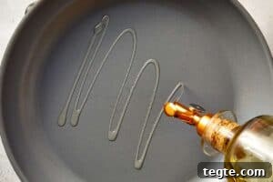 Skillet being drizzled with olive oil