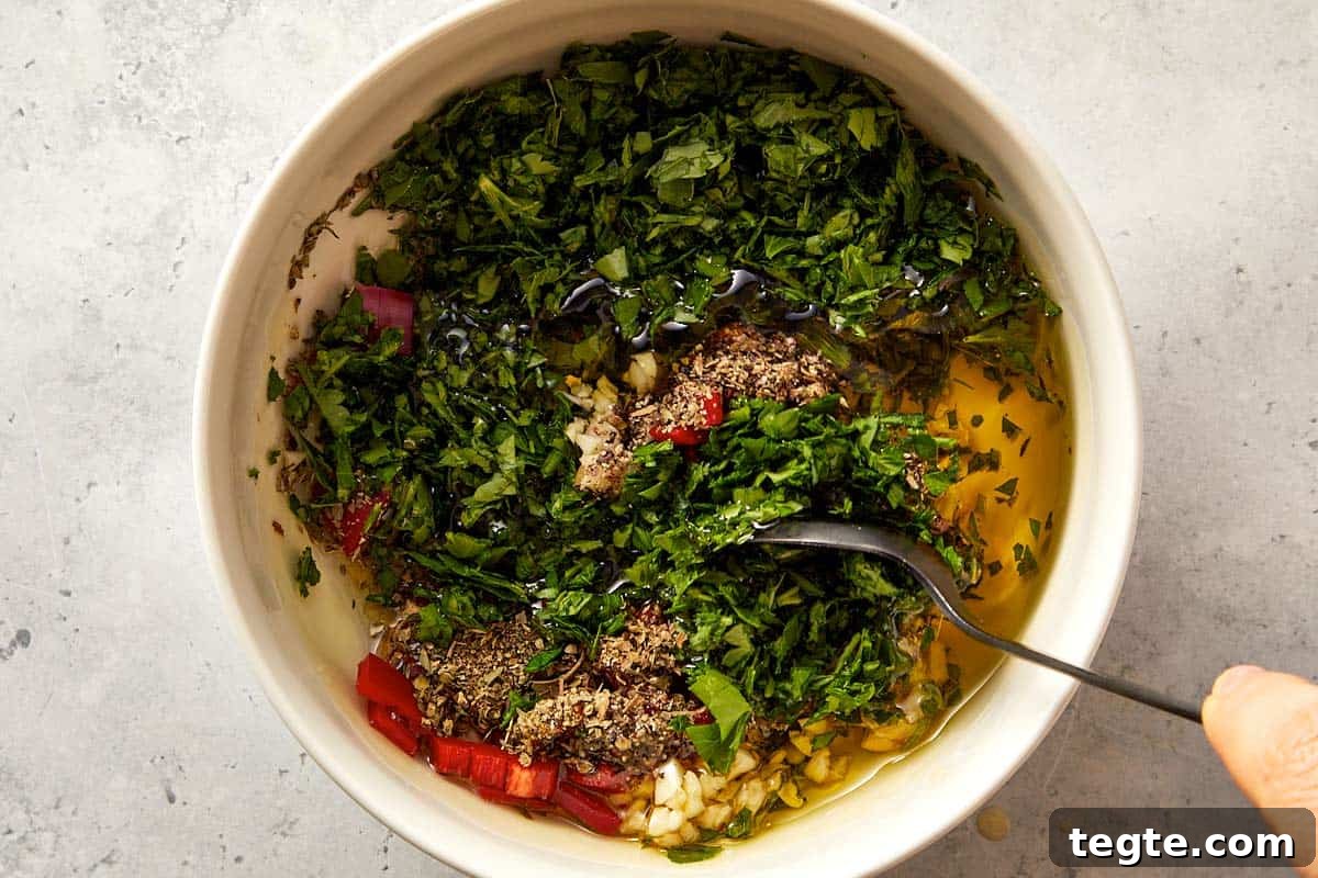 Top overview of chimichurri being mix in a white surface