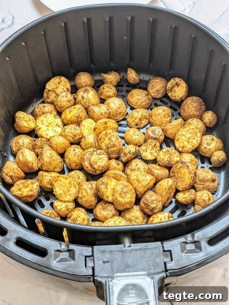 Roasted baby potatoes after air frying in air fryer basket.