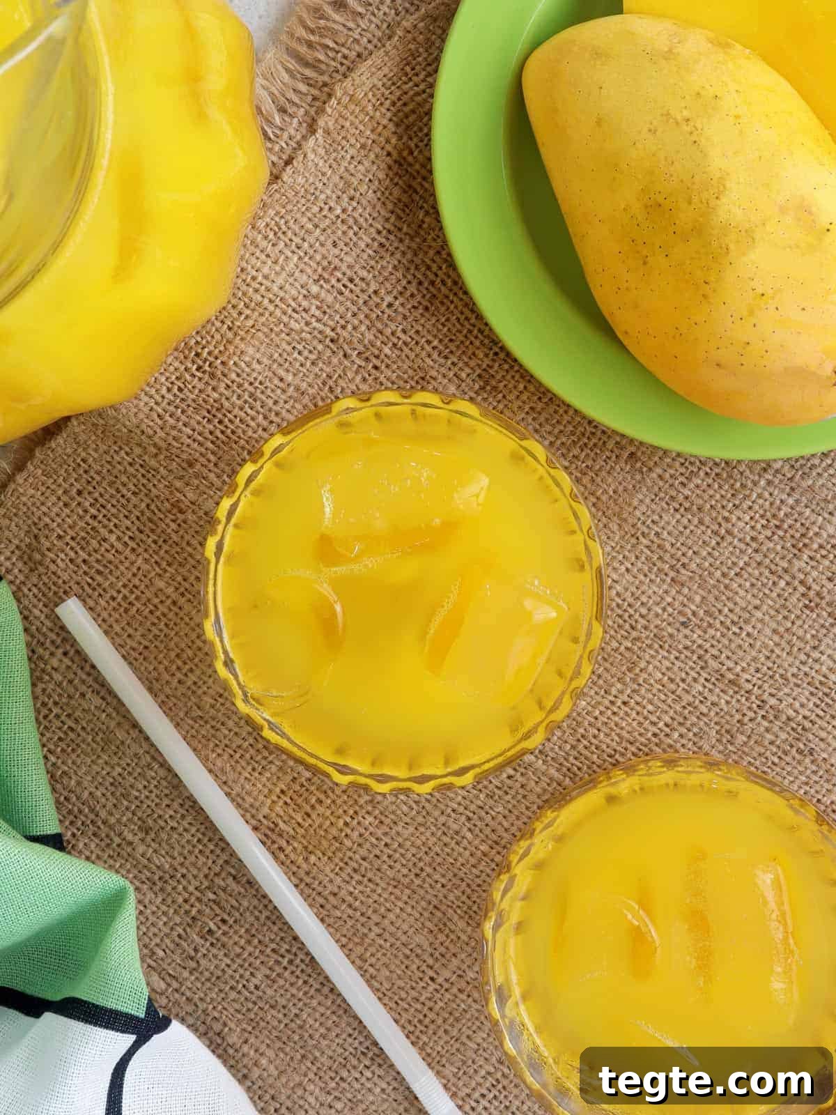 Homemade Mango Nectar Recipe: Smooth, Fresh Mango Drink 2 mango nectar in clear glasses with fresh mango fruit on the side