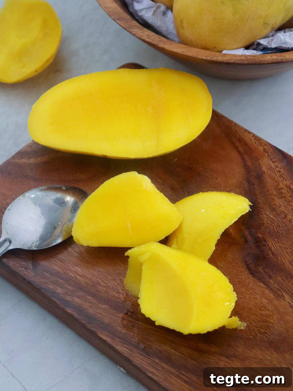 Homemade Mango Nectar Recipe: Smooth, Fresh Mango Drink 4 mango pieces on a wooden cutting board