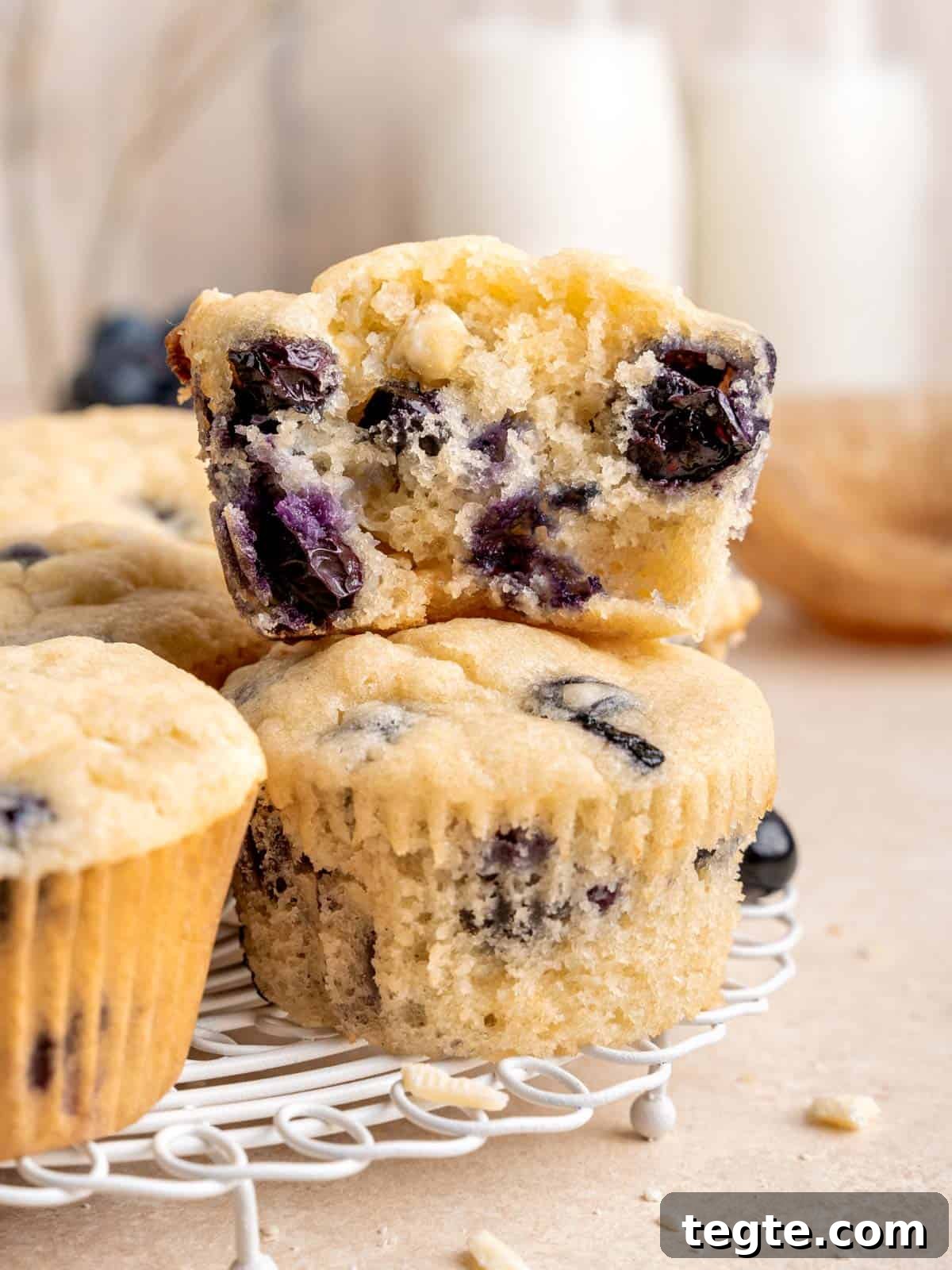 Half of a white chocolate blueberry muffin stacked on a whole one.