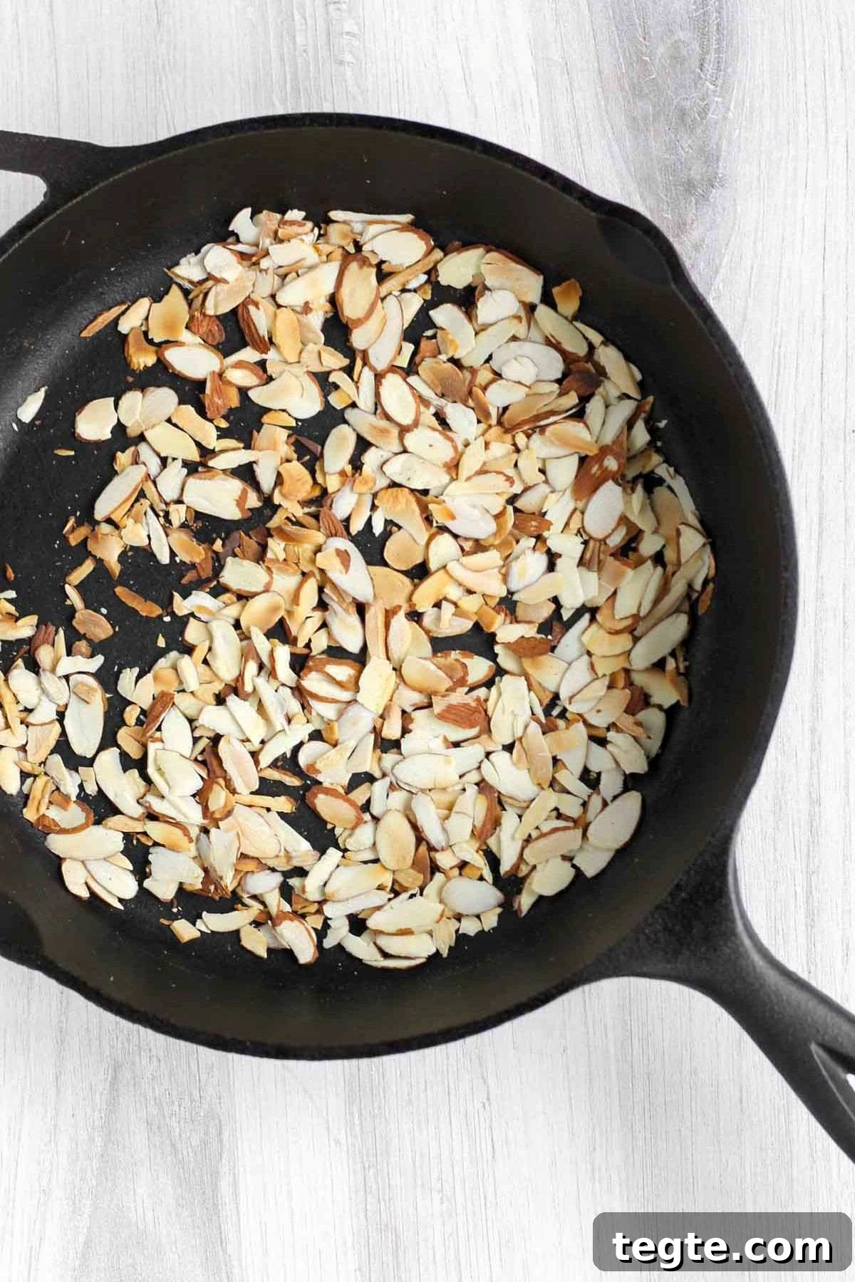 Toasted sliced almonds in a cast iron skillet.