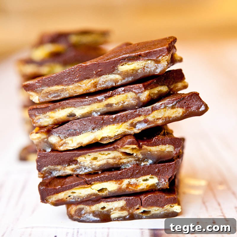 A stack of chocolate-covered toffee bars with nuts.