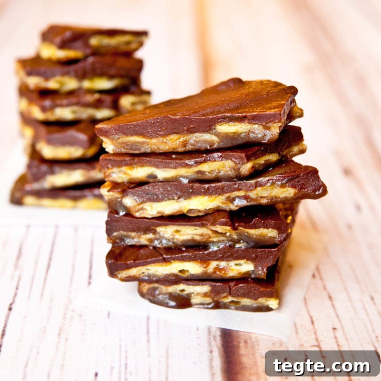 stacks of christmas crack candy on parchment paper squares
