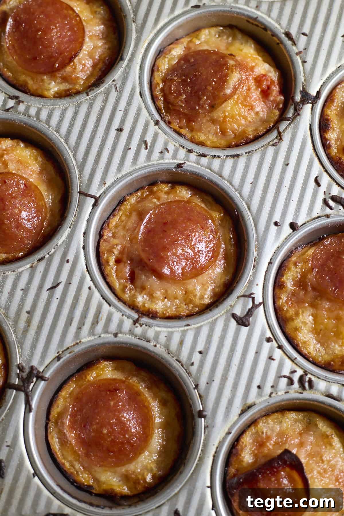 Mini Sourdough Discard Pizzas: Crispy Tiny Pizzas from Leftover Starter 9 Miniature pizzas in the muffin pan after baking.