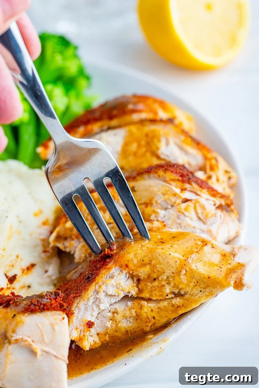 sliced chicken breast with a fork and gravy.