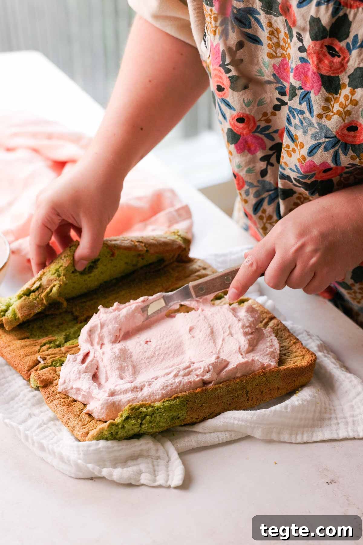 Raspberry and Pistachio Cake Roll Recipe for Spring Gatherings 13 spreading raspberry mascarpone filling on pistachio cake