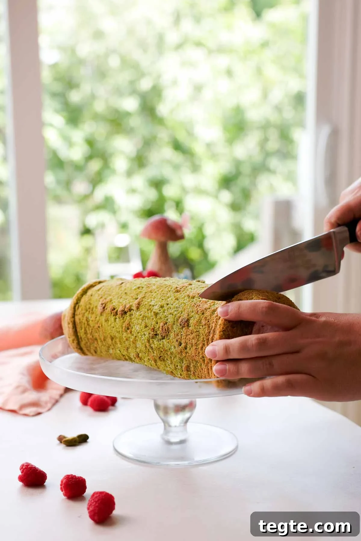 Raspberry and Pistachio Cake Roll Recipe for Spring Gatherings 15 slicing ends off pistachio roll cake