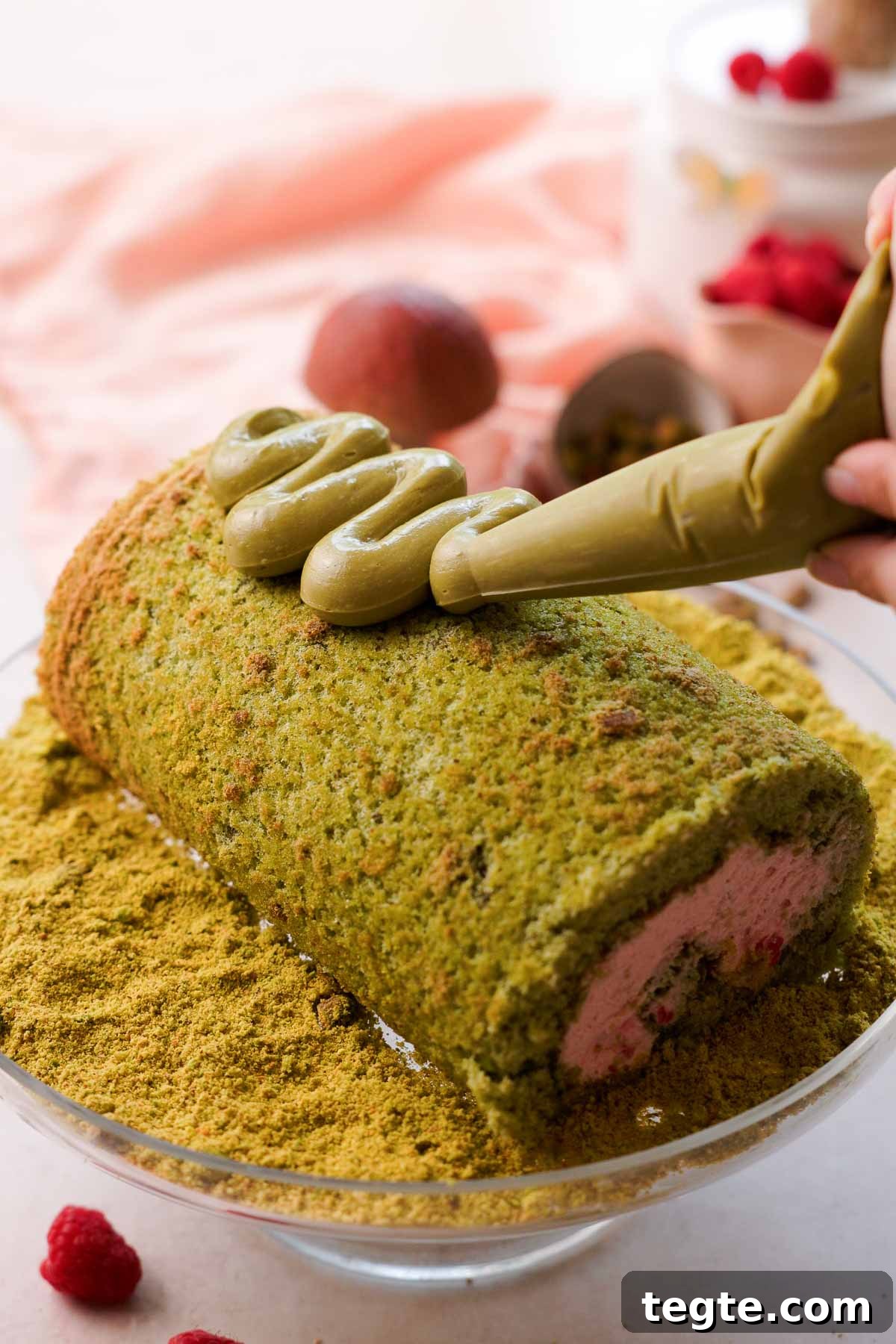 Raspberry and Pistachio Cake Roll Recipe for Spring Gatherings 16 piping pistachio spread on top of roll cake