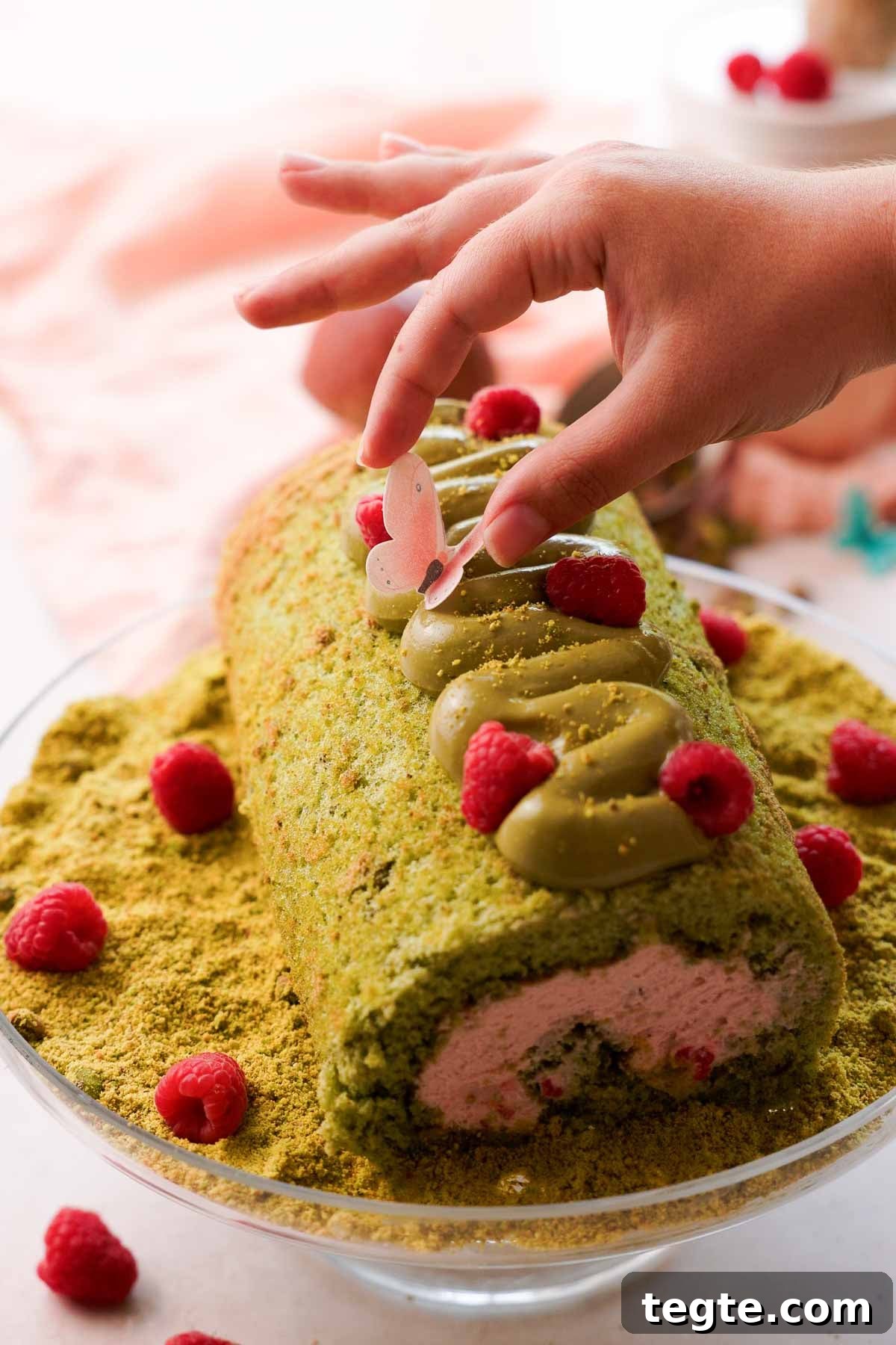 Raspberry and Pistachio Cake Roll Recipe for Spring Gatherings 17 decorating pistachio cake roll with edible butterflies