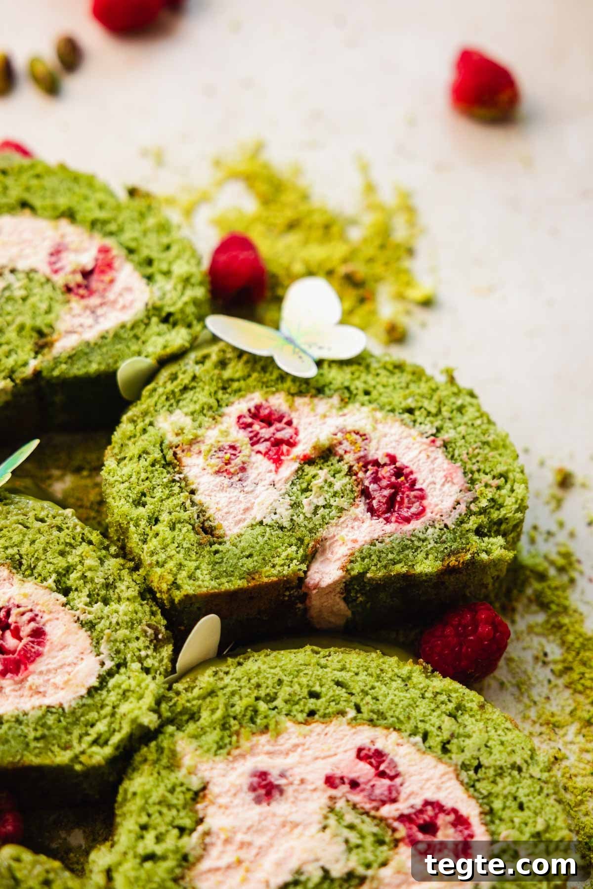 Raspberry and Pistachio Cake Roll Recipe for Spring Gatherings 3 slices of pistachio cake roll with fresh raspberries inside filling