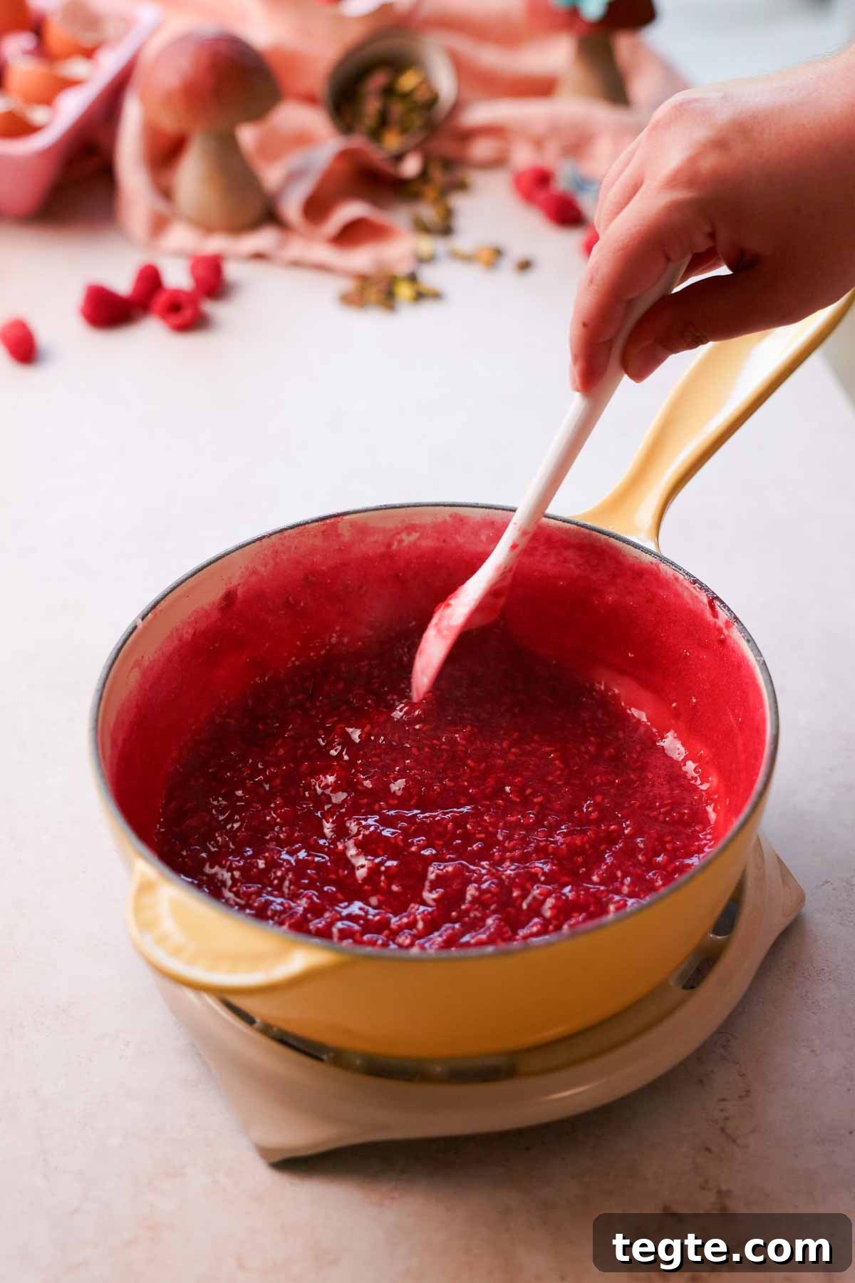 Raspberry and Pistachio Cake Roll Recipe for Spring Gatherings 9 simmered and reduced raspberry sauce in saucepan