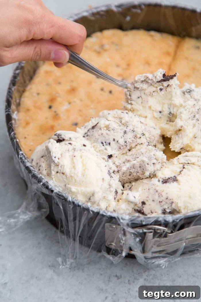 Cookies and Cream Ice Cream Cake Recipe for Rich, No-Bake Dessert 4 Layered ice cream cake featuring cookies and cream and chopped Oreos.