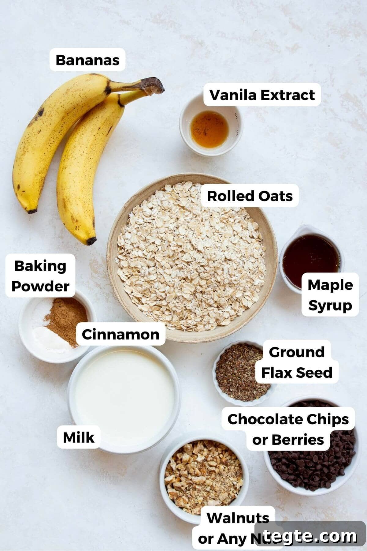 Vegan Baked Oatmeal Recipe for Busy Mornings 3 All ingredients in this vegan baked oatmeal recipe in small bowls, including: rolled oats, vanilla, bananas, maple syrup, baking powder, cinnamon, ground flax seeds, and plant milk.