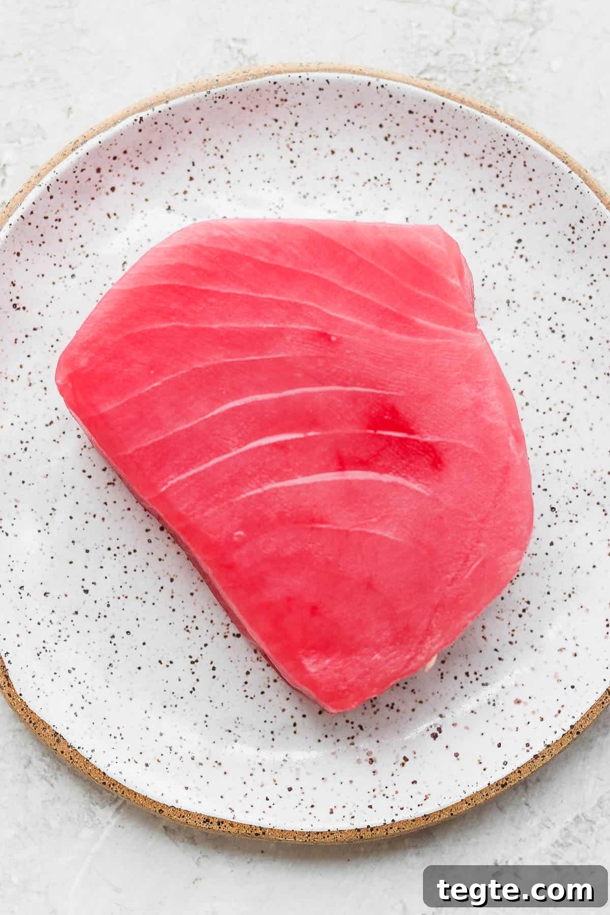 Fresh Tuna Poke Bowl Recipe: Quick Hawaiian-Style Lunch 4 A piece of raw ahi tuna on a plate.