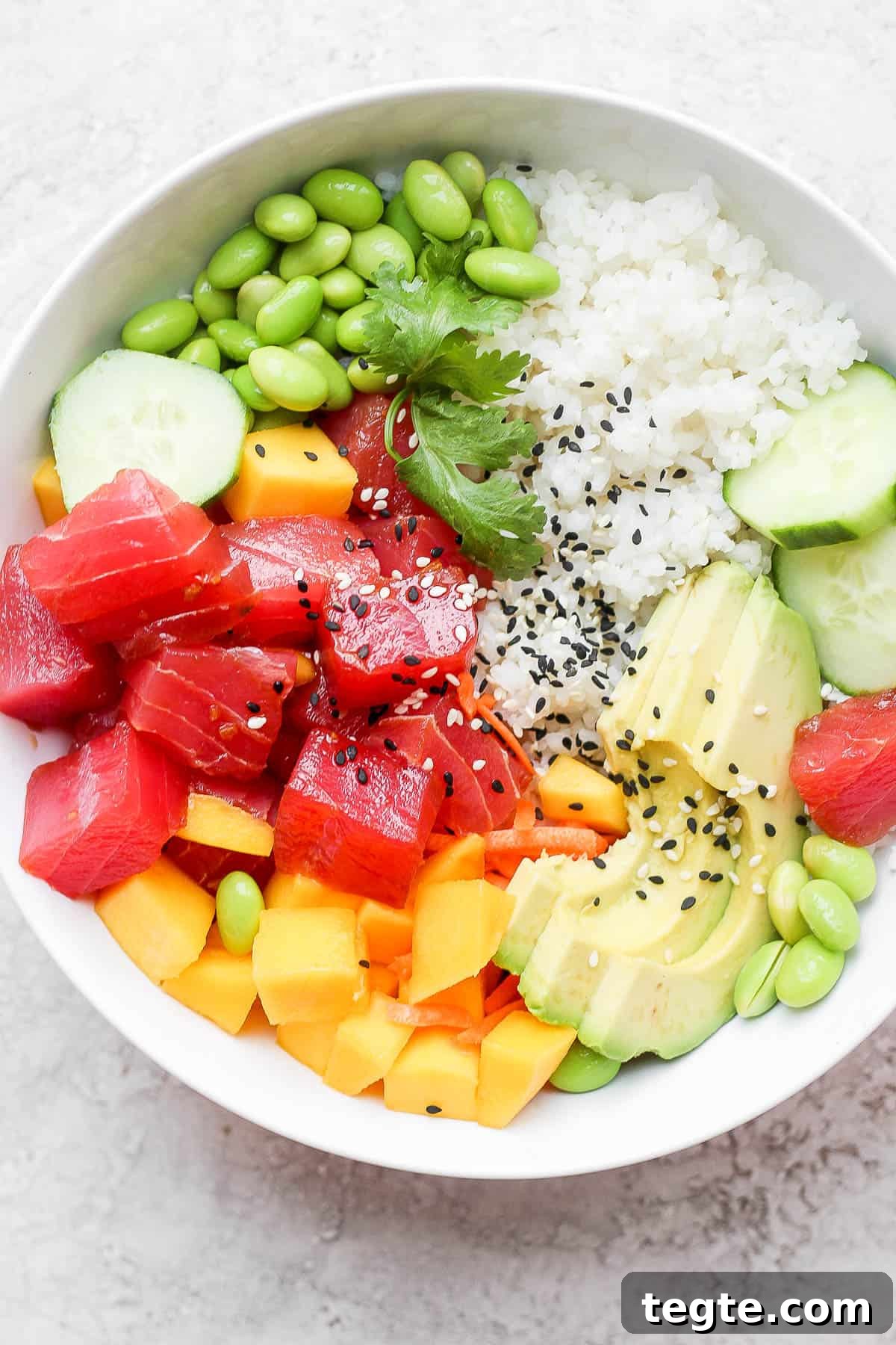 Fresh Tuna Poke Bowl Recipe: Quick Hawaiian-Style Lunch 6 Tuna poke bowl with sushi rice, edamame, cucumber, mango, avocado and cilantro.