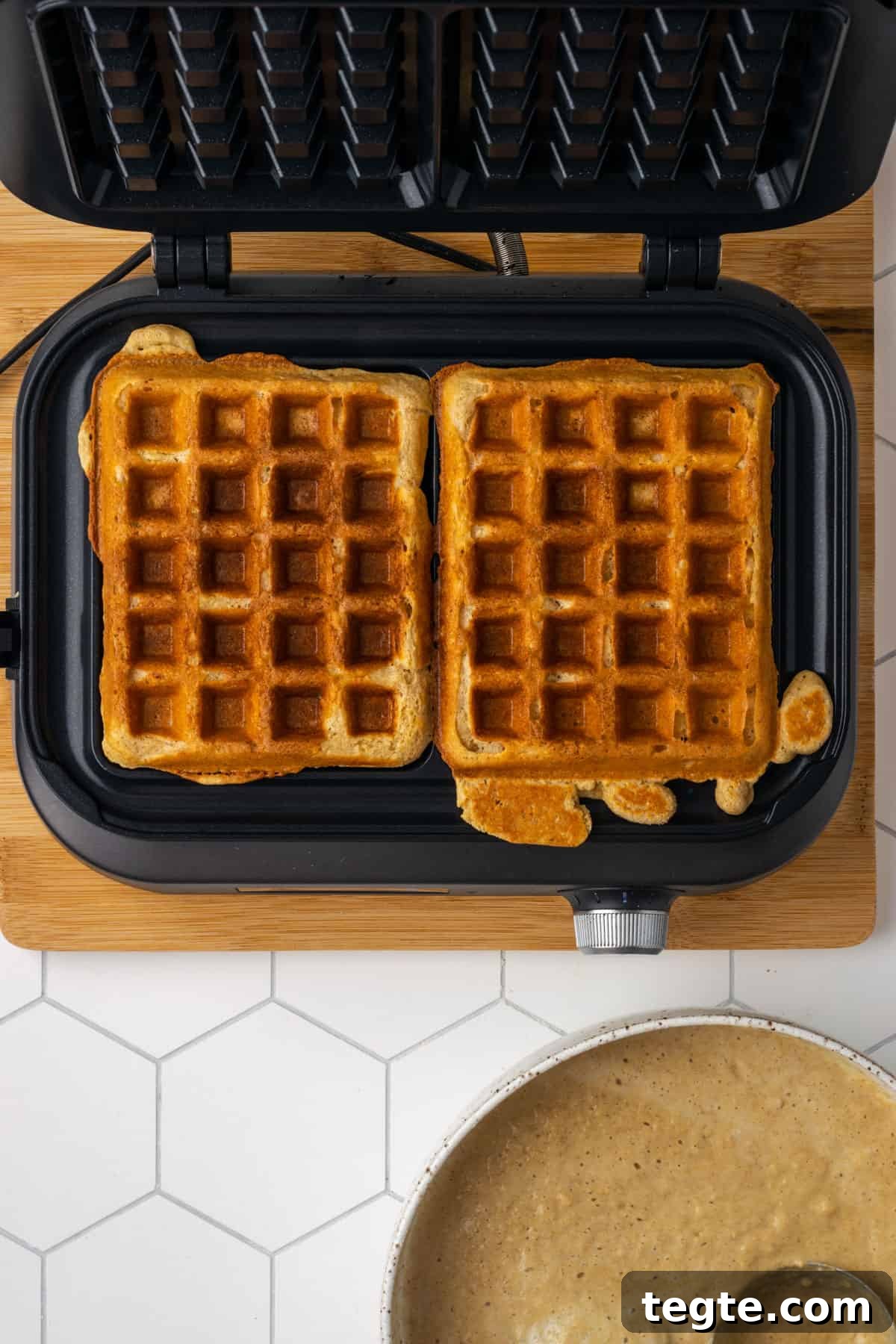 Crispy Oat Flour Waffles Recipe - Fluffy & Gluten-Free Option 4 Golden brown, freshly cooked oat flour waffles sitting on a waffle iron.