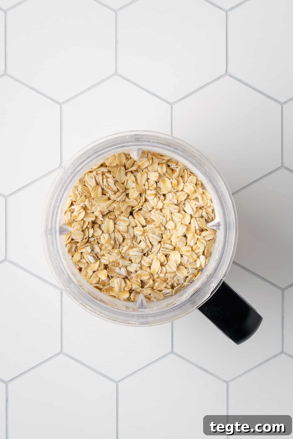 Crispy Oat Flour Waffles Recipe - Fluffy & Gluten-Free Option 5 Old-fashioned oats in a blender jar sitting on a white table.