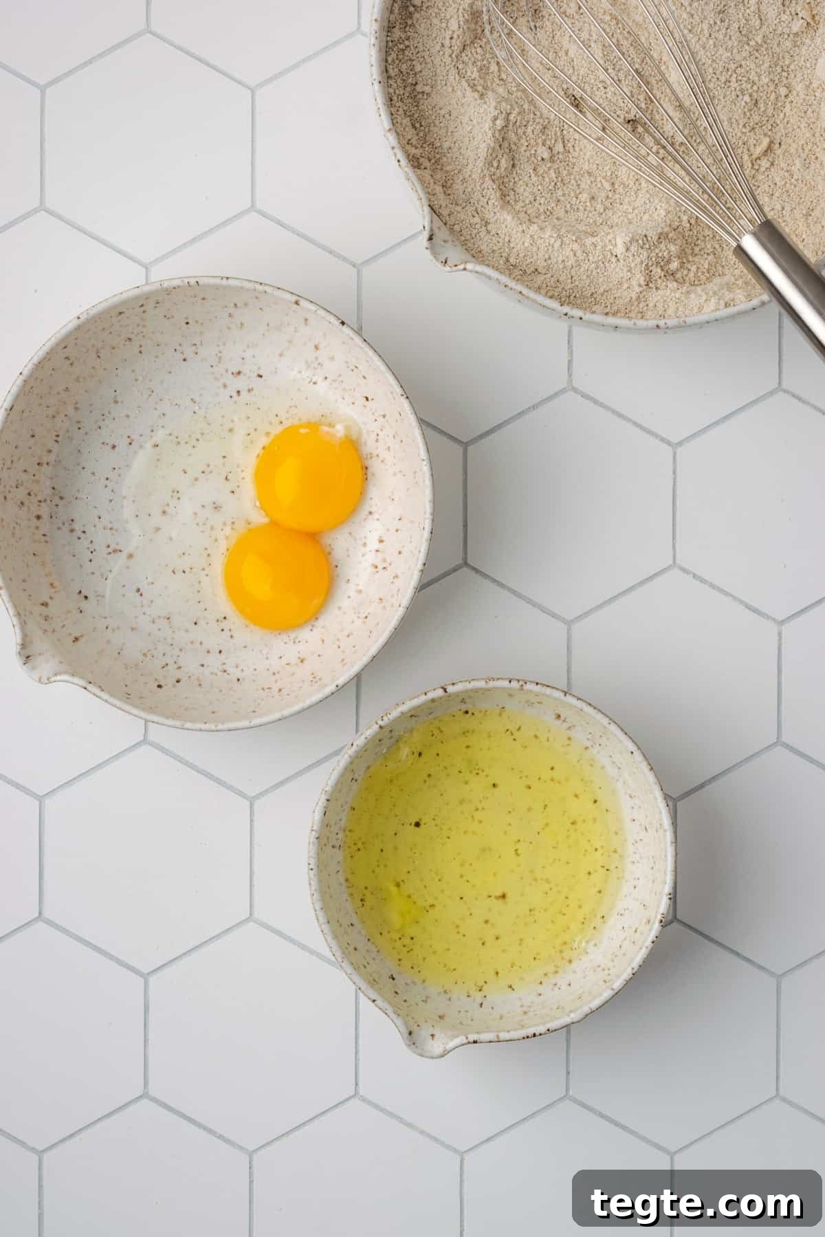 Crispy Oat Flour Waffles Recipe - Fluffy & Gluten-Free Option 8 Two white bowls on a table, one with two egg yolks and the second with egg whites.