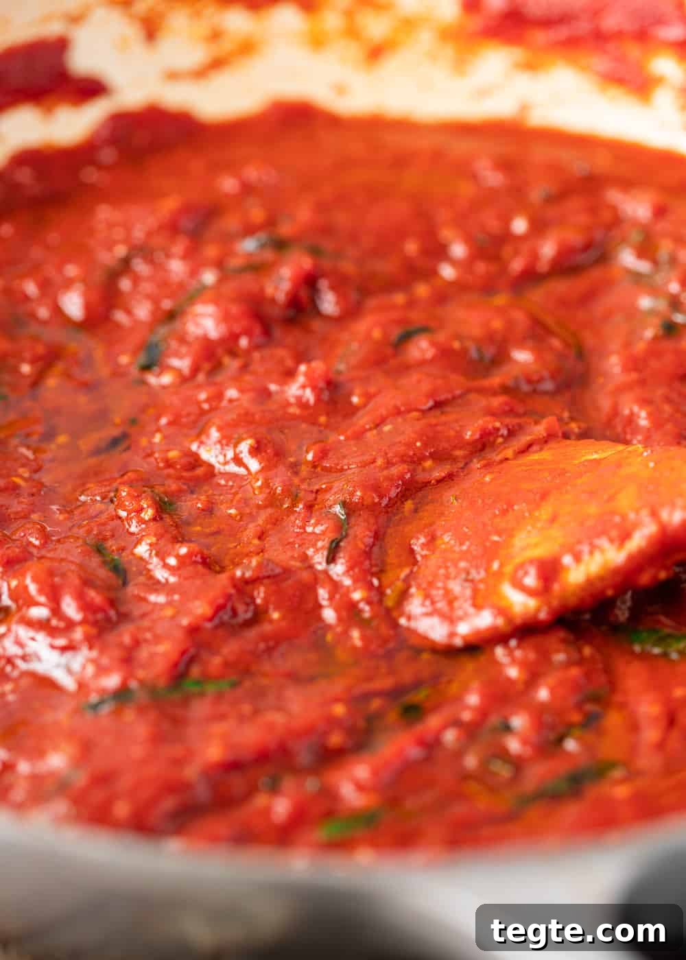 Homemade Marinara Sauce for Spaghetti (Meatless) 5 closeup: meatless spaghetti sauce cooking with a wooden spoon stirring