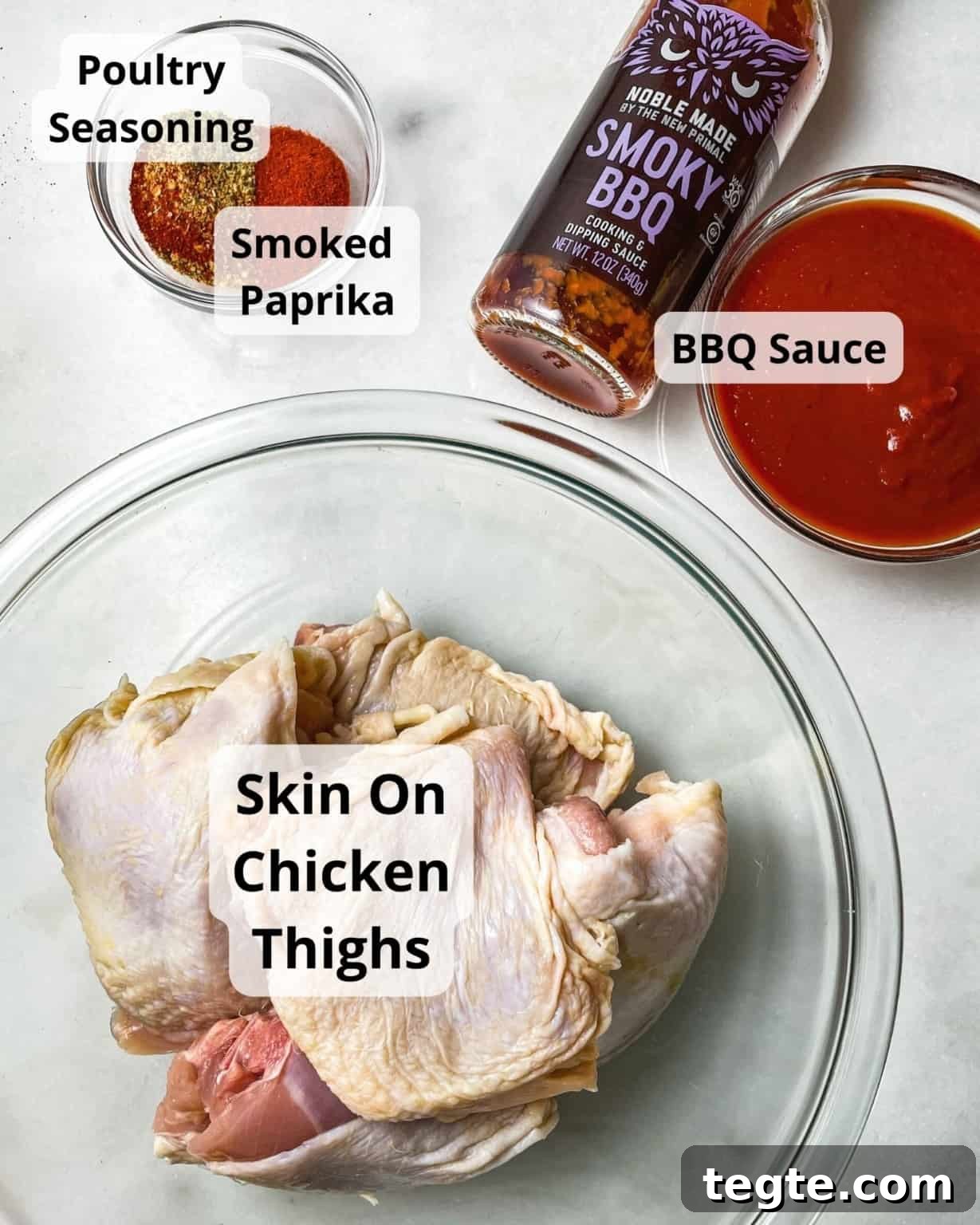 Oven-Baked BBQ Chicken Thighs with Crispy Skin and Sticky Glaze 3 ingredients to make baked bbq chicken thighs - chicken thighs, bbq sauce, poultry seasoning, and smoked paprika.