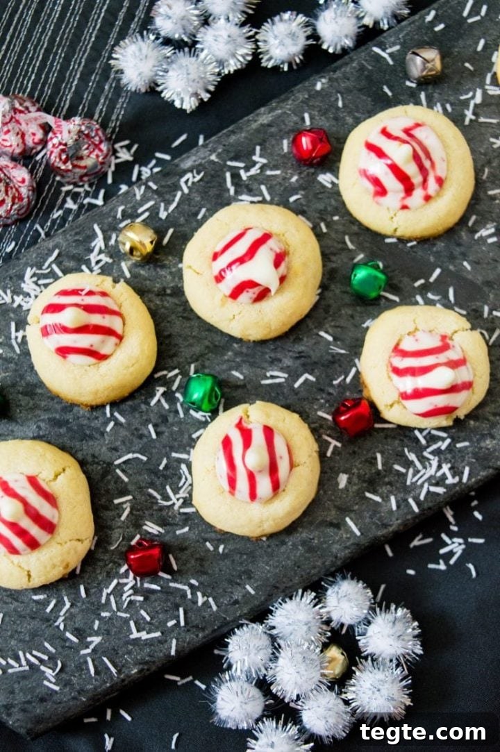 several candy cane Hershey kiss sugar cookies on a dark surface