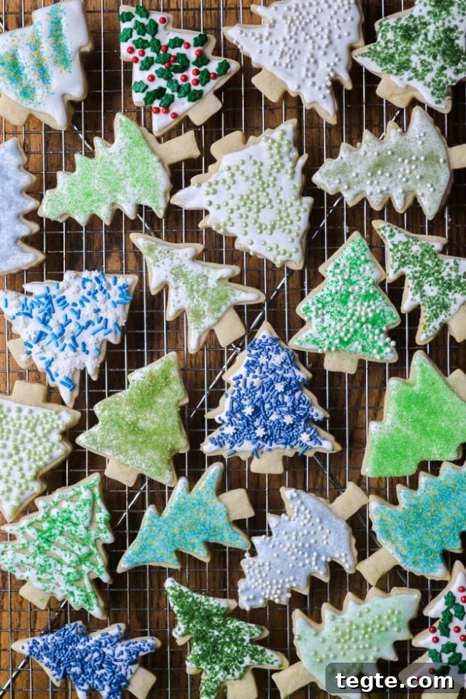 several christmas tree shaped holiday sugar cookies with DIY colored sugar on a wire rack