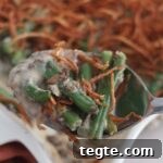 Gluten-Free Green Bean Casserole Recipe for Holiday Dinners 19 large spoonful of green bean casserole above entire casserole.