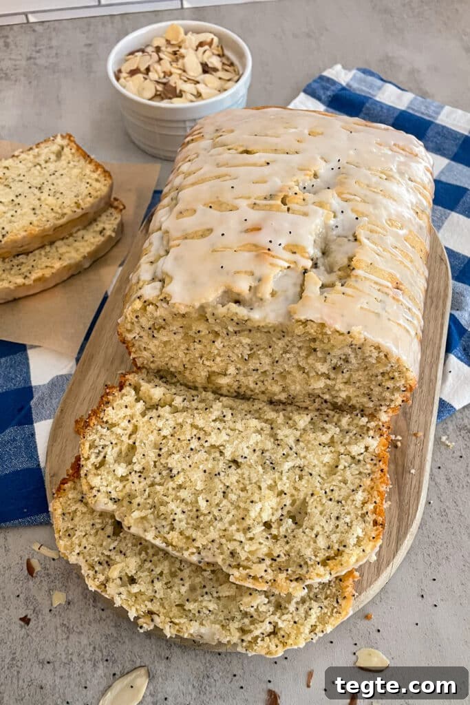 Almond Poppy Seed Quick Bread Recipe for Moist Loaves 3 loaf of easy almond poppyseed bread shown on a cutting board with slices for serving and a bowl of sliced almonds