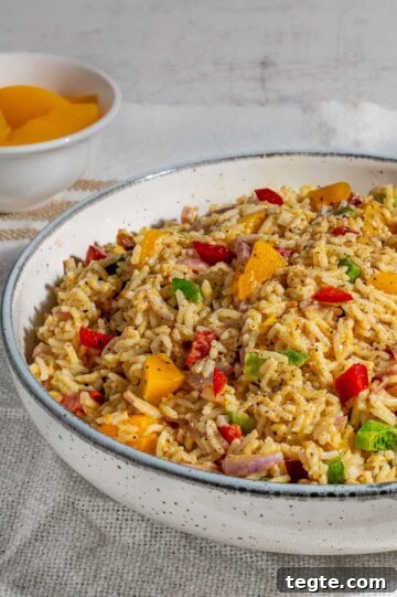 Curried rice salad in a white bowl on a white background.