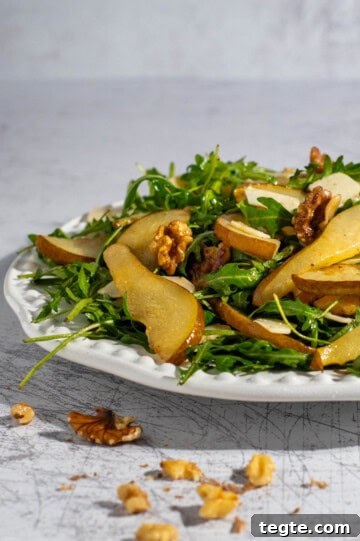 Pear and rocket salad on a large white plate.