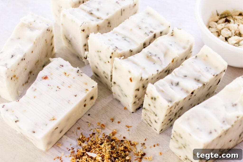 Make Herbal Soap Using Dried Herbs: Step-by-Step Guide 11 Homemade herbal soap bars curing on a white table with dried flower petals all around it.