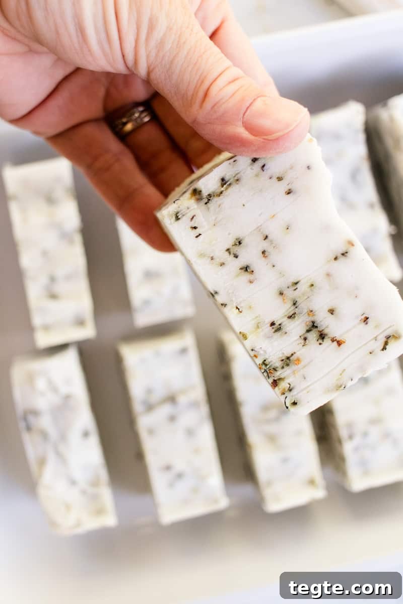 Make Herbal Soap Using Dried Herbs: Step-by-Step Guide 12 Holding a newly cured herbal soap bar up for a close up shot.