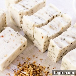 Make Herbal Soap Using Dried Herbs: Step-by-Step Guide 16 Homemade herbal soap bars curing on a white table with dried flower petals all around it.