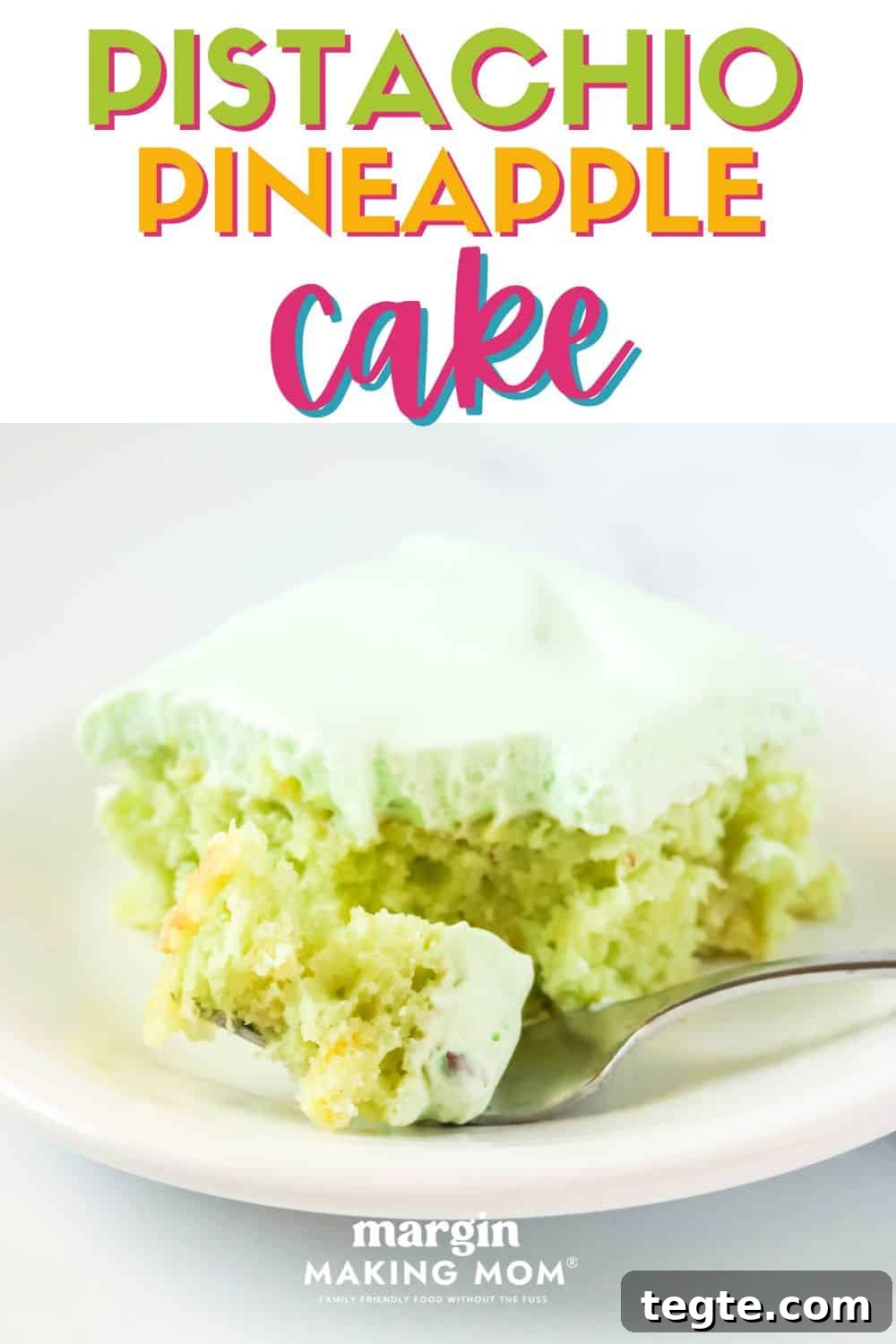 a slice of frosted pistachio pineapple cake on a white plate. A fork has removed a bite of the cake and is resting on the plate.
