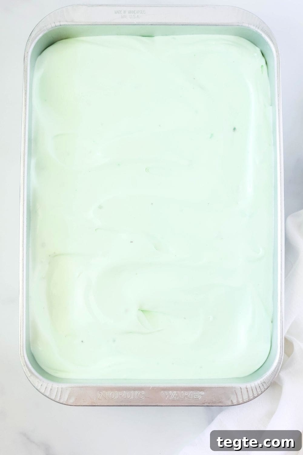overhead view of a 9x13" cake pan, with pistachio and pineapple cake in it.